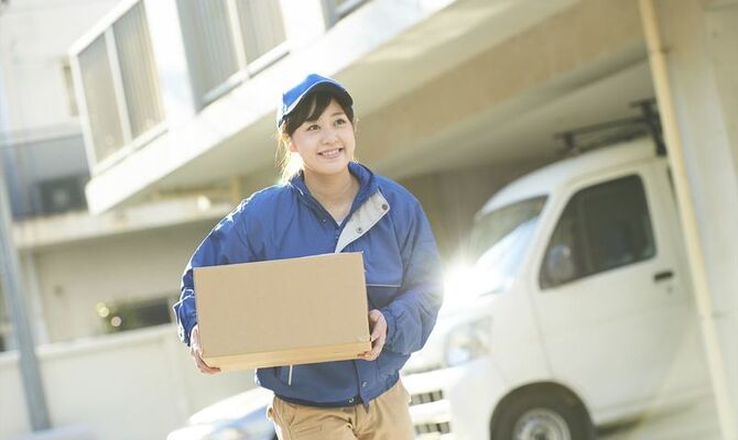 走りながら小包を運ぶ女性スタッフ